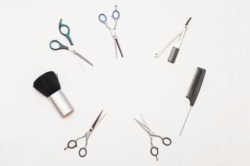 Different scissors and combs on a white background for a professional hairdresser
