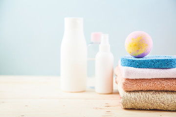 Obraz na płótnie Canvas bathroom accessories - towels, cream, bath foam and shampoos on a light, bright background Concept of caring for yourself, your body Place for copy space.