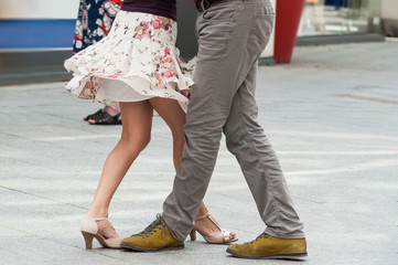 closeup of legs of couple of tango dancers in the street