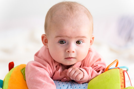 Cute baby girl on bed looking at camera