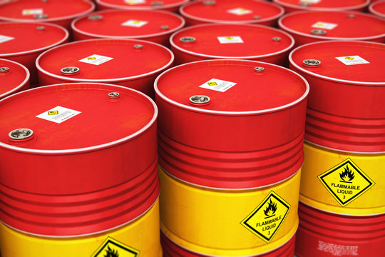 Group of rows of red stacked oil drums in storage warehouse