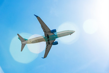 Fototapeta na wymiar Passenger plane flying in the blue sky in sunlight rays
