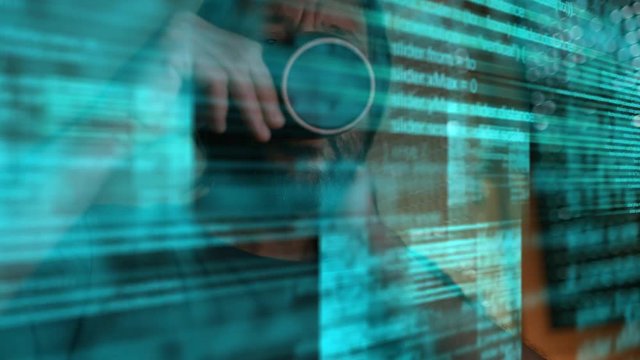 Web designer drinking coffee and analyzing code on computer monitor in dark office interior