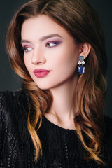 Beautiful girl in a black dress. model with make-up. Studio portrait