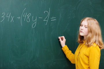 A girl at the blackboard in a mathematics class