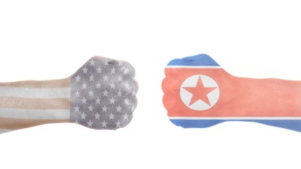 USA and North Korea flags painted on two clenched fists.USA vs North Korea concept.