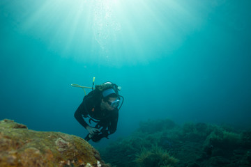 Female scuba diver in beautiful blue tropical underwater