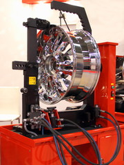 Equipment for car service and repair - chrome wheel on the tire machine for rolling and leveling...