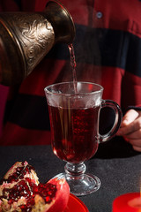 A young girl with red hair is preparing mulled wine. Red and black palette
