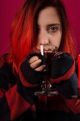 A young girl with red hair is preparing mulled wine. Red and black palette