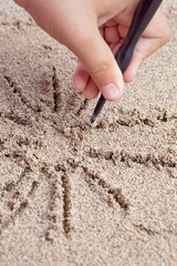 Child draws a stick on the sea with the sun. Children's drawing.