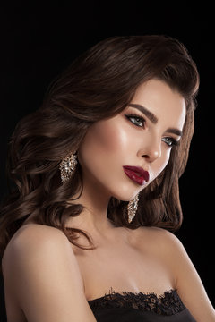 Fashion glamorous portrait of a girl on a dark background. Elegant hairstyle, bright makeup and lip color. Hollywood picture.