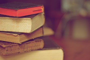 Old books pile on top of each other with a blur background