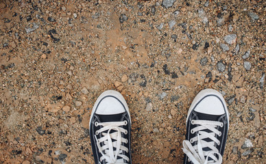 Sneakers on the gravel. Copy space. Walking on foot. Modern comfort. Shoes for Travel.