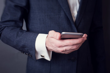 businessman in suit holding smartphone
