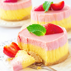Delicious homemade mango strawberry cheesecake white background Copy space Selective focus Square image.