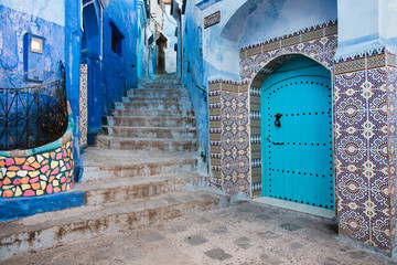 Naklejka premium Blue Door with Blue Stone Buildings and Stairs, Chefchaouen Medina, Morocco