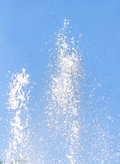 The fountain splashes against the sky