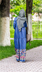 Fototapeta na wymiar Girl in a Muslim dress in a city park in spring