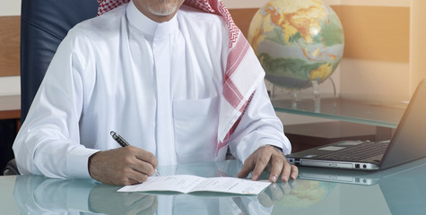 Senior Saudi Businessman Hand Writing At His Desk