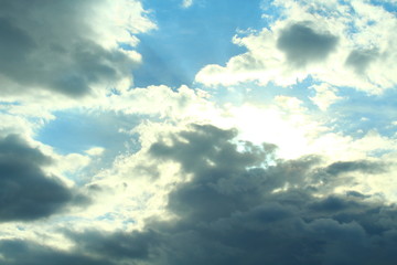 A beautiful cloudy sky, cumulus clouds and scorching sun. Background. Landscape.