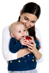 A happy mother is holding a small daughter with a Christmas tree