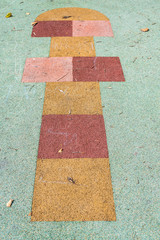 Children's game of cork hopscotch on the ground of a park