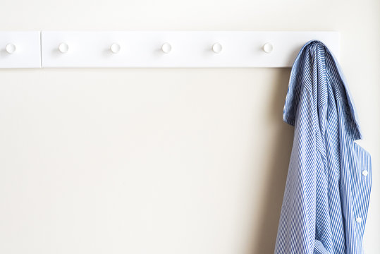 Simple white wall coat hanger with a hanging shirt