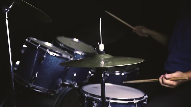Dust from drum set with a man sitting in low light background, Cinemagraph.