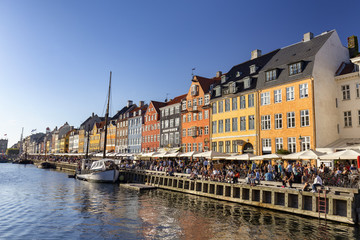Fototapeta na wymiar COPENHAGEN, DENMARK - AUGUST 26: Unidentified pedestrians walk past beautiful buildings in Copenhagen, Denmark on August 26, 2016.