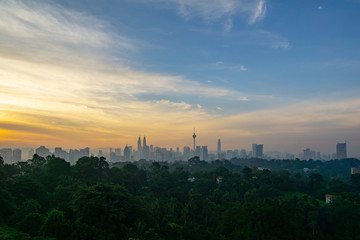 Obraz premium Cloudy sunrise over KL Tower and surrounded buildings in downtown Kuala Lumpur, Malaysia. 