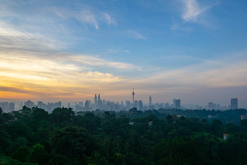 Cloudy sunrise over KL Tower and surrounded buildings in downtown Kuala Lumpur, Malaysia.	