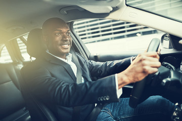 African businessman smiling during his drive to work