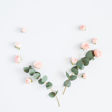 Flowers composition. Heart symbol made of rose flowers, eucalyptus branches on pastel gray background. Flat lay, top view, copy space, square