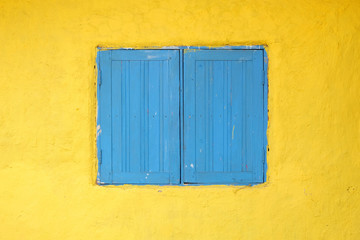 Obraz na płótnie Canvas Blue wooden window on the yellow background