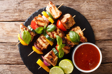 spicy grilled chicken kebabs with vegetables served with ketchup close-up. horizontal top view