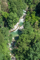 Fototapeta na wymiar Forest river flowing between two high rocks with green plants in Georgia. Okatse canyon