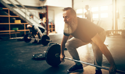 Focused mature man preparing to lift weights during a workout