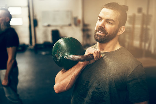 Fit Young Man Holding A Dumbell At The Gym