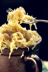 Sauerkraut on a fork with a shallow depth of field. Pickling cabbage at home. The best natural probiotic.