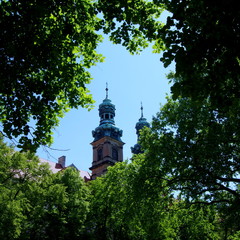 Widok na wieżę klasztoru w zespole klasztorny-pałacowym w Lubiążu założonym przez Cystersów - wieża widziana z pobliskich ogrodów przez drzewa © Konrad_elx