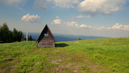 Zielona łąka przy drewnianej wacie i końcu wyciągu orczykowego w Karkonoszach © Konrad_elx