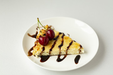 Dessert-cheesecake with cherry berries and chocolate sauce. Isolated on white