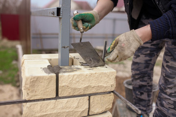 The man at the construction site is laying bricks