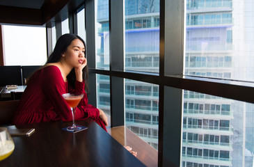 Pensive girl having a drink in a bar