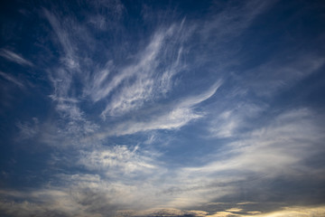 Blue dark sky with windy clouds on an abstract background