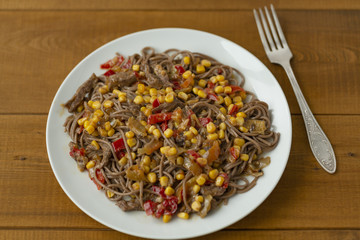 Soba noodles with beef, corn, onions and sweet peppers. Top view