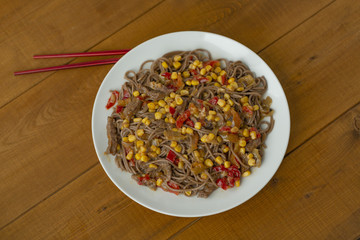 Soba noodles with beef, corn, onions and sweet peppers. Top view