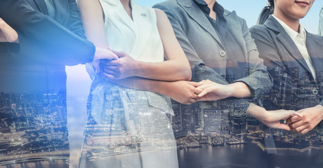 Double exposure business people holding hands.