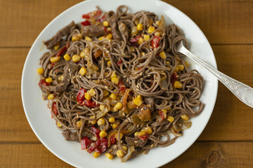 Soba noodles with beef, corn, onions and sweet peppers. Top view